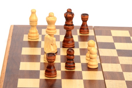 A chess board and figures on it on white backgroundの写真素材