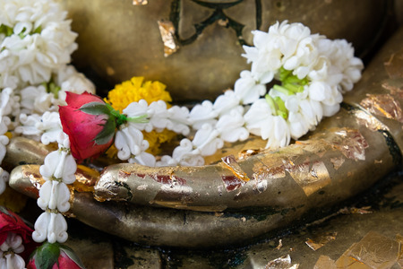 garland in hands of Buddha statueの写真素材