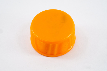 orange plastic bottle cap isolated on whiteの写真素材