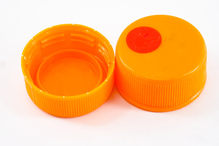 orange plastic bottle cap isolated on whiteの写真素材