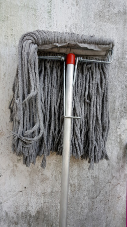 Dirty mop on wall backgroundの写真素材