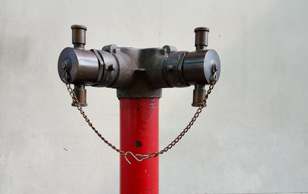 Old red metallic fire hydrant on streetの写真素材
