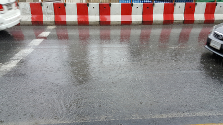 car goes to rain on city streetの写真素材