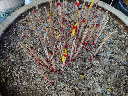burning incense sticks in a buddhist temple in bangkok, thailandの写真素材