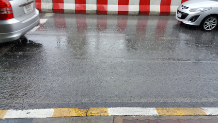 car goes to rain on city streetの写真素材