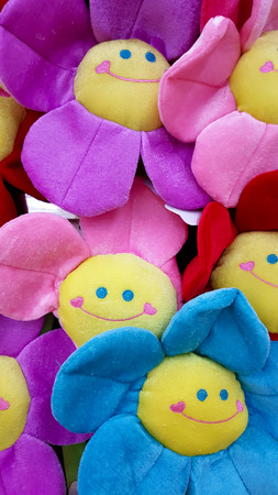 Smiling flower toy with green leaves isolated on whiteの写真素材