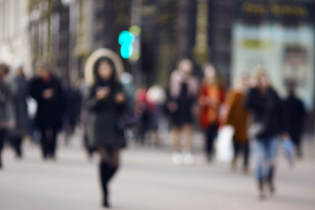 Blurred background which shows the figures of people hurrying to cross the roadway at a green traffic lightの写真素材