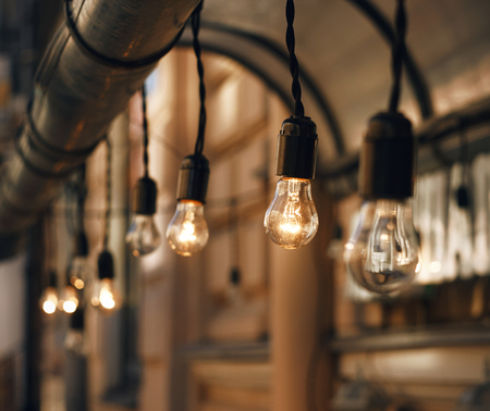 Beautiful decor lighting - hanging on the wire glowing lamps, some of which are extinguished.