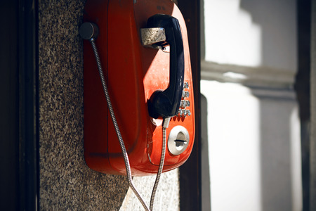 Street red retro telephone, available for everyone, which illuminates the solar bright light.の写真素材