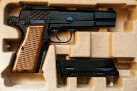 In a cardboard box is an airsoft gun with a brown handle, and next to it is a magazine. Sale and...