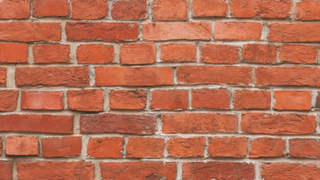 A smooth solid wall of old red historical bricks worn by time. Background from the wall.