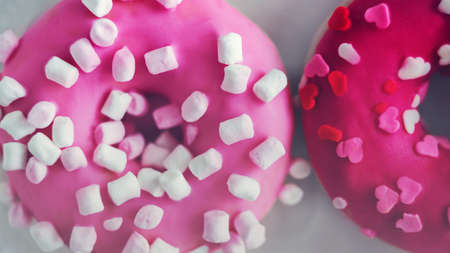 Two sweet delicious pink donuts with marshmallow and red hearts sprinkle. A nice gift for...