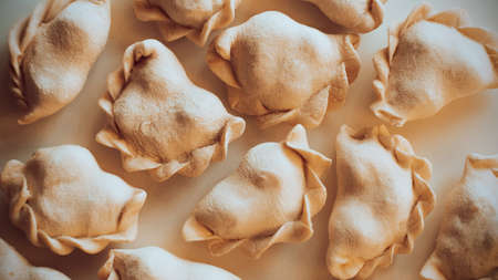 Top view of frozen delicious homemade dumplings. Dough with filling inside. Russian cuisine. Frozen semi-finished products.の写真素材