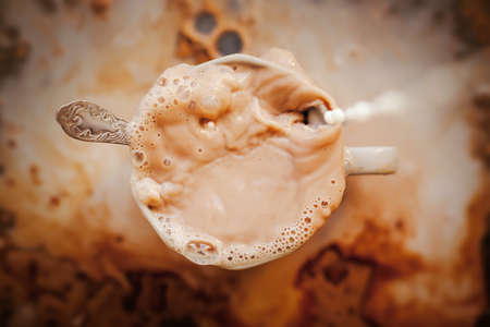 The human was pouring milk into a coffee mug. Mess in the kitchen. A pleasant invigorating drink for breakfast. Ice coffee.の写真素材
