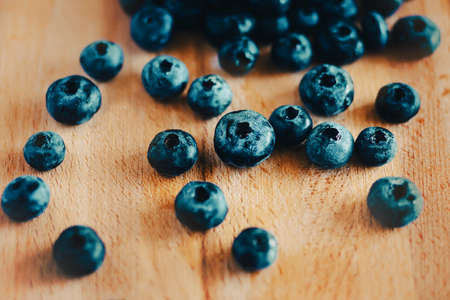Ripe delicious washed blueberries are lying on a wooden cutting board. Berry harvest. Healthy proper nutrition. Diet and vegetarianism.の写真素材