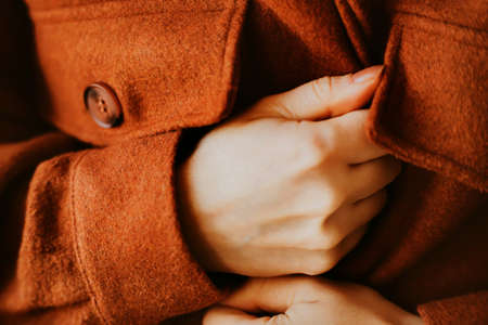 The woman is dressed in a warm soft woolen ginger shirt in the autumn cold. Casual comfortable clothes. Season.の写真素材