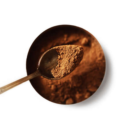 Top view of a jar with natural aromatic cocoa powder, from which a portion is taken out with a teaspoon to prepare a drink. Isolate.の写真素材