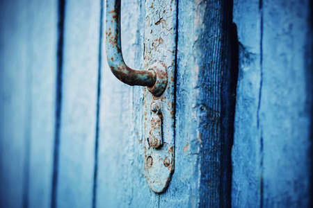 An old blue wooden door with a rusty metal handle. A closed door to the house. The mystery is behind the door. retro.の写真素材