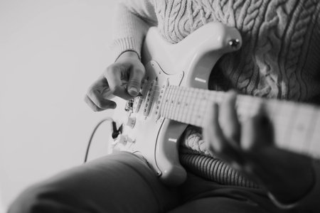A black and white image of a musician playing music on a white electric guitar. guitar solo. music lessons. Art.の写真素材