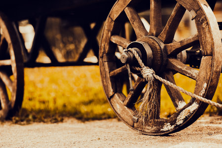 An old wooden cart sits abandoned in the field, its wheels creaking with rust and age. This sight evokes memories of a simpler time, when transport was slow and labor-intensive.の写真素材