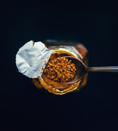 In the photo, there is a jar of instant coffee and a teaspoon with which a portion of coffee is...