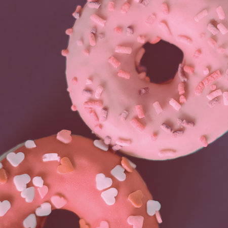 Two pink sweet donuts, sprinkled with a sweetness. A treat for Valentine's Day.の写真素材