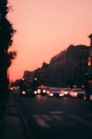 A blurry photo of a city highway at sunset. The lights of the cars are slightly out of focus and look like glowing lights.の写真素材
