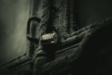A black-and-white photograph of an old house with a hanging lock on the door, leading to a dark and mysterious interior. The image evokes a sense of horror and intrigue.の写真素材