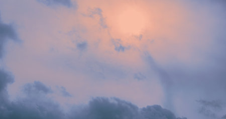 In the sky, the soft light of the rising sun breaks through the delicate clouds in the morning,...