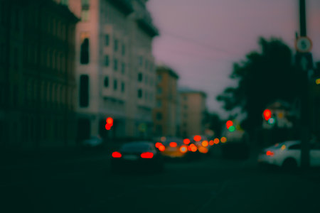 A blurry photo of a nighttime street, with multicolored car headlights sparkling on the road ahead. Traffic in the city is busy.の写真素材