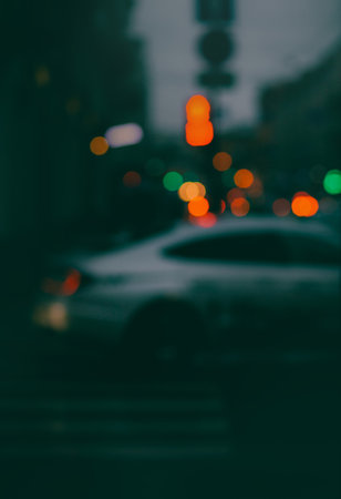 A blurry photo of a nighttime street with multicolored car headlights sparkling on the road ahead. The traffic in the city is busy.の写真素材