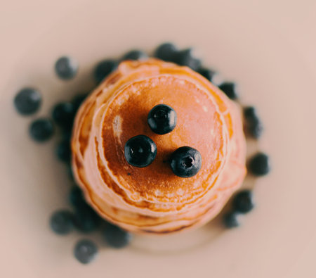 A beautiful close-up of delicious, freshly made pancakes for breakfast, beautifully decorated with ripe blueberries. A healthy and delicious breakfast.の写真素材