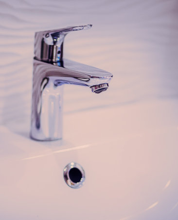 The bathroom has a white sink with a stainless steel faucet and a soap dish containing soap. This ensures cleanliness and hygiene.の写真素材