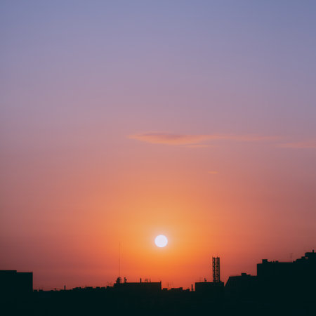 A beautiful, gentle dawn is rising over the dark rooftops of the big city, creating a peaceful and quiet morning atmosphere.の写真素材