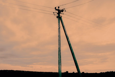 A photo of a power line against a beautiful sunset sky, with the countryside in the background.の写真素材