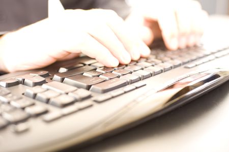 Caucasian male hands on a keyboard. Shallow DOF with strong light burnout on hands and keyboard for...