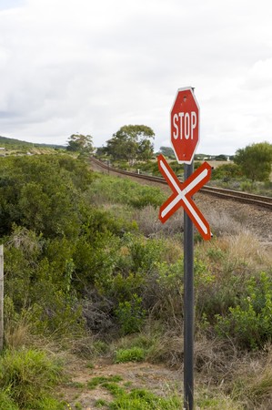 A stop sign at a railroad crossing, indicating a single rail to be crossed.