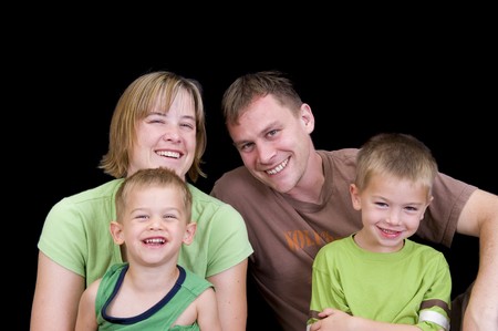 An adorable young family playing and having fun. Studio shot isolated on black.