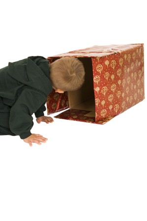 Young boy sneaking a peek in a Christmas box. Isolated on white. の写真素材