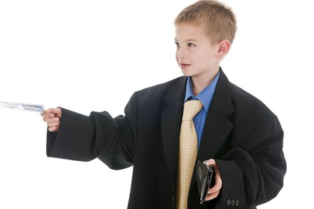 A small boy in the studio, dressed up in his father's suit and pretending to be a businessman,...