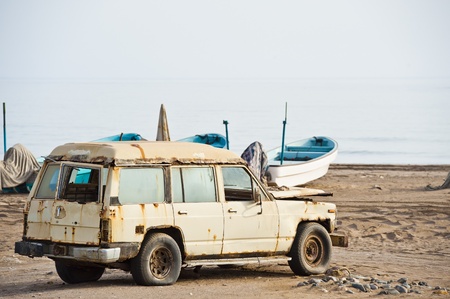 An old rusted 4x4 vehicle used by fisherman, abandoned on a beach in the Seeb area of Muscat, Oman.の写真素材