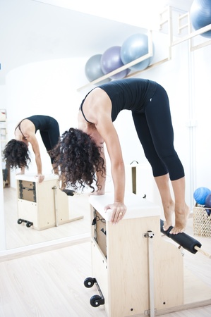 An attractive young lady performing a Pilates exercise with resistance from equipment.の写真素材