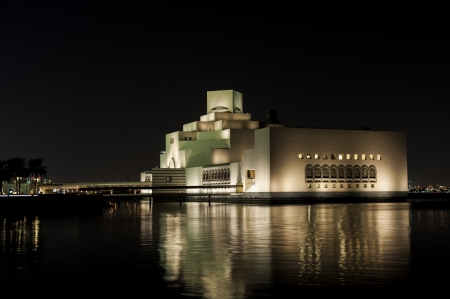 Night shot of the Doha Museum of Islamic Art, showing the strong reflections of light made by the building design のeditorial素材