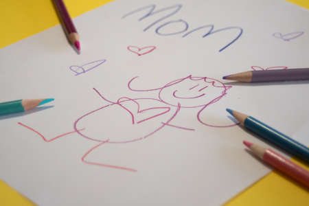 child's drawing for mom on yellow backgroundの写真素材