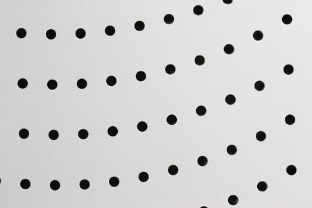 Round holes in a metal surface of grey colourの写真素材