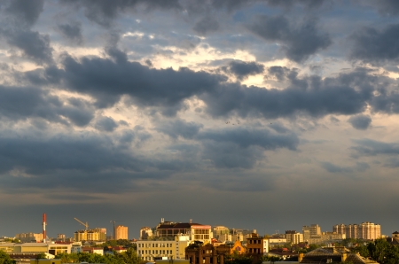 Under the dark sky of a top of houses are shined with beams of the coming sunの写真素材