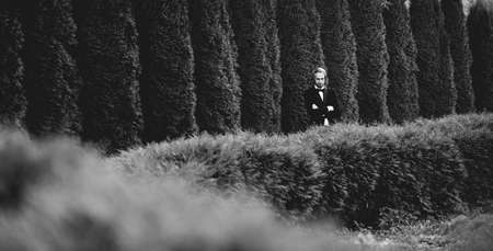 Romantic, fairytale, happy newlywed couple hugging and kissing in a park, trees in background, wedding day.の写真素材