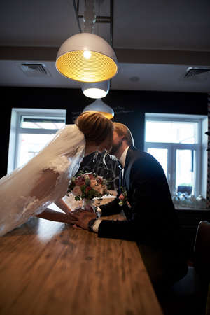 Wedding couple, groom and bride, together in a restaurant on wedding dayの写真素材