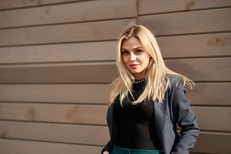 Street portrait of pretty lovely young woman in elegant stylish suit with beautiful hair near old...