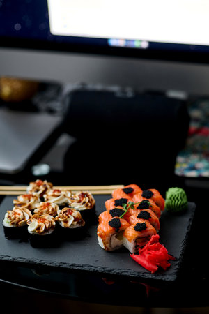 Sushi rolls on a black plate with chopsticks on a black backgroundの写真素材